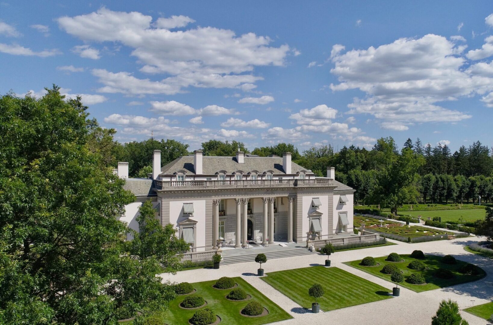 A large white building with trees in the background