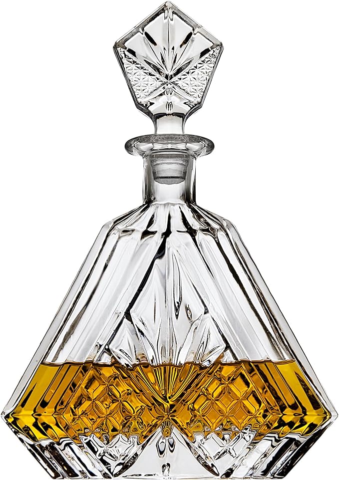 A glass decanter with a decorative design on the bottom.