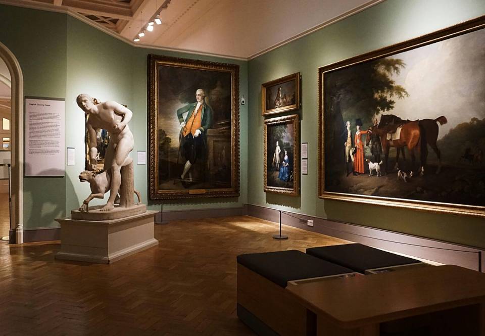 A room filled with paintings and sculptures on display.