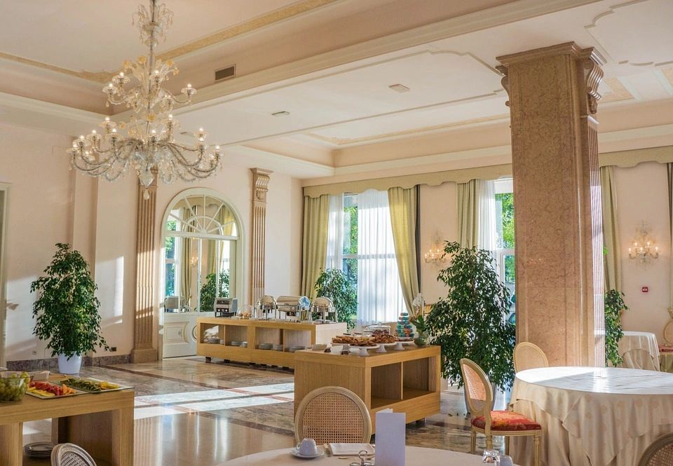 A dining room with a chandelier and many tables