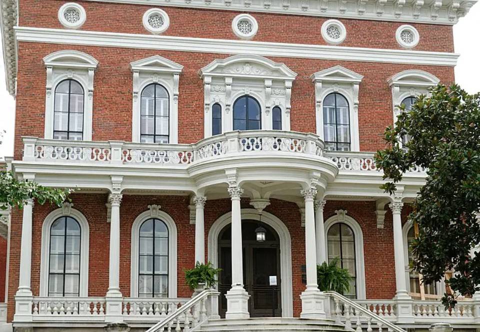 A large red brick building with white columns and windows.