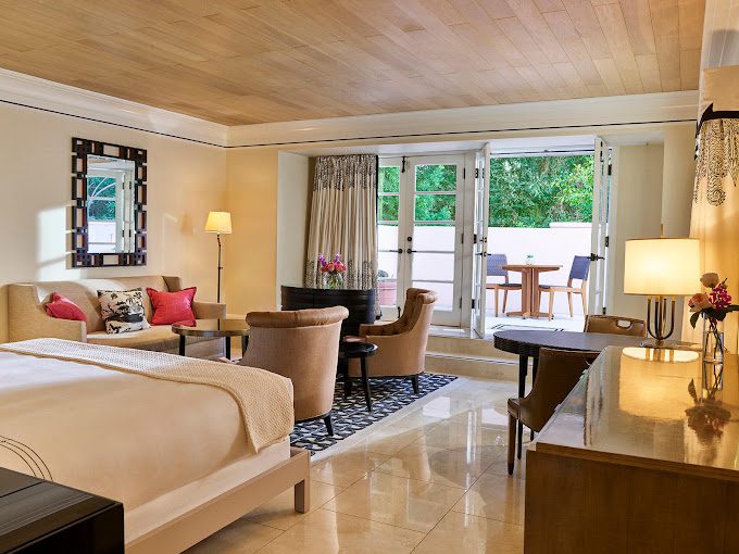 A hotel room with a bed, desk and chairs.