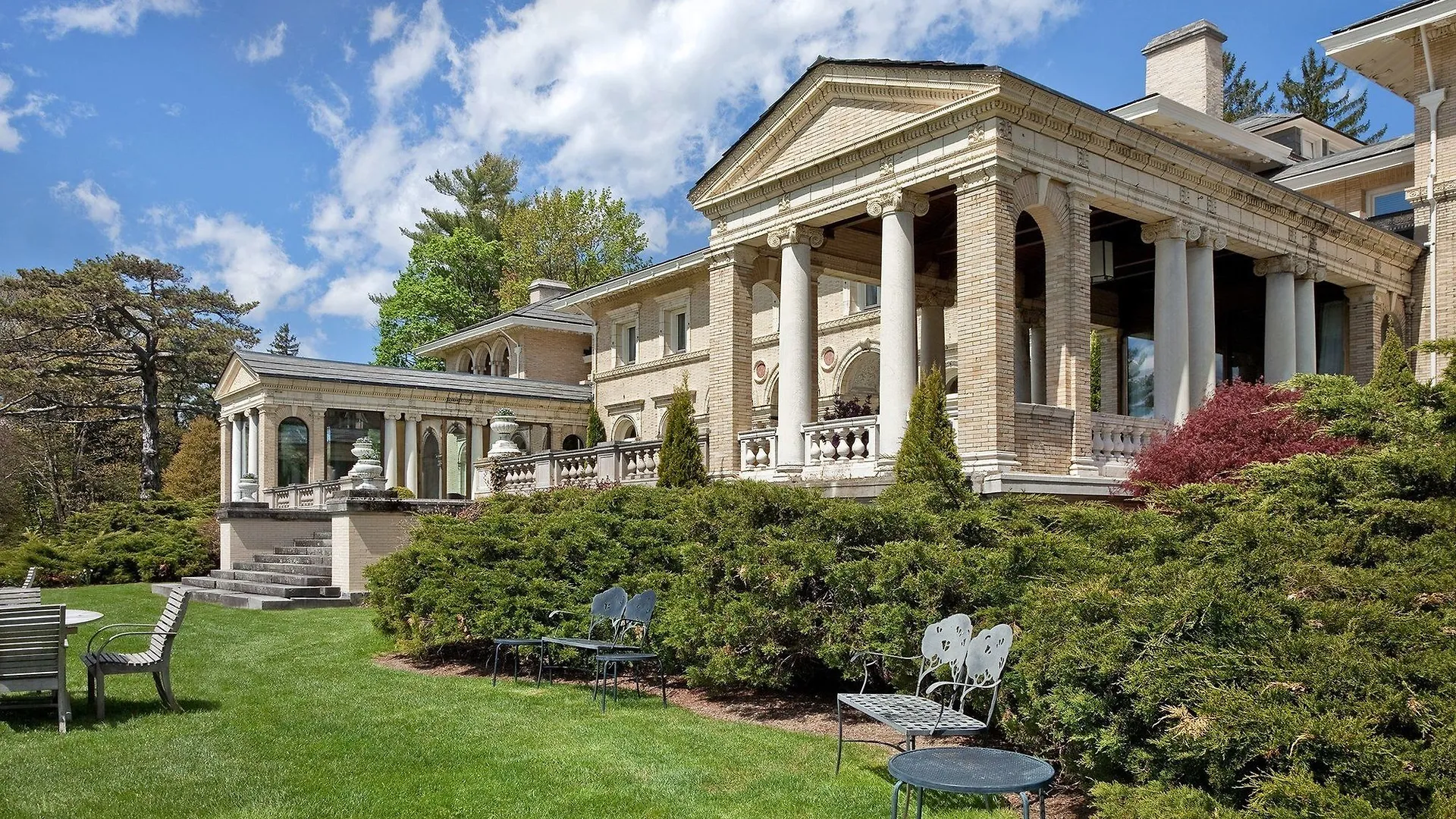 A large mansion with many trees and bushes