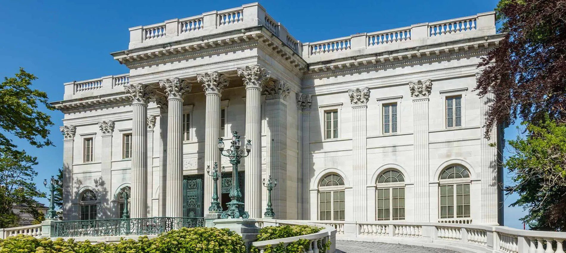 A large white building with columns and statues.