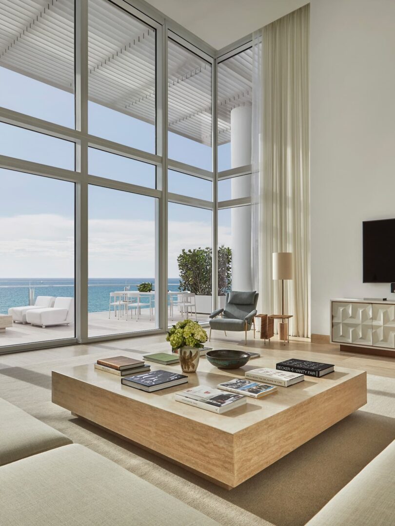 A living room with large windows and a view of the ocean.